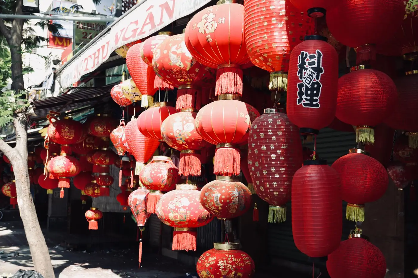 Red paper lanterns glowing above a busy night-market street